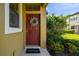 Inviting front door with wreath, 'welcome' mat, and lush landscaping provides a warm and welcoming entrance at 11519 Crowned Sparrow Ln, Tampa, FL 33626