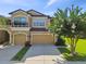Charming two-story home with a two-car garage, a small balcony, and a well-manicured front lawn with a decorative tree at 11519 Crowned Sparrow Ln, Tampa, FL 33626