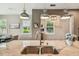 Close up of the kitchen island showcasing the sink, faucet, granite countertops and modern pendant lighting at 11519 Crowned Sparrow Ln, Tampa, FL 33626