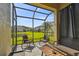 Screened lanai with seating overlooking a pond and manicured lawns at 11519 Crowned Sparrow Ln, Tampa, FL 33626