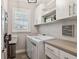 Bright laundry room with front loading washer and dryer, built-in cabinets, and natural light at 11519 Crowned Sparrow Ln, Tampa, FL 33626
