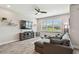 Inviting living room featuring a comfortable sectional sofa, ceiling fan, and large window at 11519 Crowned Sparrow Ln, Tampa, FL 33626