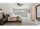 Spacious main bedroom with a ceiling fan, plush carpet, and windows with plantation shutters at 11519 Crowned Sparrow Ln, Tampa, FL 33626