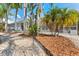 Landscaped backyard features tropical plants, white rocks, and a screened-in pool area, offering a serene outdoor space at 12910 Vicksburg Dr, Tampa, FL 33625