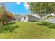 Spacious backyard boasts a well-maintained lawn, screened patio, and privacy fence, ideal for outdoor activities at 12910 Vicksburg Dr, Tampa, FL 33625