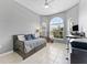 Bright bedroom with daybed, tile flooring, a ceiling fan, and large arched windows at 12910 Vicksburg Dr, Tampa, FL 33625