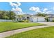 Charming single-story home with a lush lawn, mature landscaping, and a three-car garage, perfect for curb appeal at 12910 Vicksburg Dr, Tampa, FL 33625