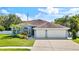 Charming single-story home features a three-car garage, well-manicured lawn, and inviting curb appeal at 12910 Vicksburg Dr, Tampa, FL 33625
