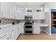 Bright kitchen with white cabinetry, stainless steel appliances, mosaic backsplash, and hardwood floors at 12910 Vicksburg Dr, Tampa, FL 33625