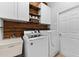 Well-equipped laundry room with white cabinets, sink, wood shelving, and modern appliances at 12910 Vicksburg Dr, Tampa, FL 33625