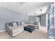 Spacious living room with a large sectional sofa, ottoman, and recessed lighting at 12910 Vicksburg Dr, Tampa, FL 33625
