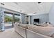Bright living room with sliding doors to a covered patio, plush carpet, and modern lighting at 12910 Vicksburg Dr, Tampa, FL 33625