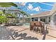 Inviting outdoor space featuring a pool, patio seating, and lush tropical landscaping, perfect for relaxation at 12910 Vicksburg Dr, Tampa, FL 33625
