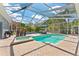 Beautiful in-ground pool area with a screened enclosure, lush landscaping, and patio seating at 12910 Vicksburg Dr, Tampa, FL 33625