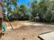 View of spacious backyard with a play area and scattered pine straw from a partial view of the deck at 13337 Tubeck St, Spring Hill, FL 34609
