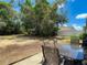 A spacious yard with scattered pine straw is seen from the patio with a dining table and chairs at 13337 Tubeck St, Spring Hill, FL 34609