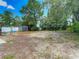 A large backyard with a storage shed, white fence, swing set, and scattered pine straw at 13337 Tubeck St, Spring Hill, FL 34609