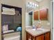 This bathroom offers a single sink vanity, neutral paint and tile accents, and dark wood storage at 13337 Tubeck St, Spring Hill, FL 34609
