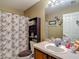 This bathroom offers a single sink vanity, neutral paint and tile accents, and a shower/tub combo at 13337 Tubeck St, Spring Hill, FL 34609