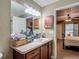 Bathroom with wooden vanity, mirror, and doorway to bedroom at 13337 Tubeck St, Spring Hill, FL 34609