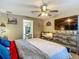Bedroom featuring rustic wood dresser, ceiling fan, tv, and ensuite bathroom at 13337 Tubeck St, Spring Hill, FL 34609