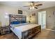 A cozy bedroom with a wooden-frame bed, ceiling fan, and doorway to a bathroom at 13337 Tubeck St, Spring Hill, FL 34609