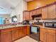 Kitchen area with dark wood cabinets and black appliances, connected to the living space at 13337 Tubeck St, Spring Hill, FL 34609