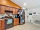 Kitchen featuring dark cabinets, stainless steel appliances, tile floor, and a pantry door at 13337 Tubeck St, Spring Hill, FL 34609