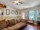 Cozy living room features hardwood floors, natural light, a ceiling fan, and wall art at 13337 Tubeck St, Spring Hill, FL 34609