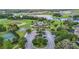 Community center aerial view with a pool, lakes, tennis court, basketball court, and parking at 13806 Reindeer Cir, Hudson, FL 34669