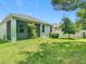 A beautiful fenced backyard with a screened in patio area and a lush green lawn and shade trees at 13806 Reindeer Cir, Hudson, FL 34669