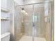 Bathroom shower with glass doors, tiled walls, built in shelves and lighting at 13806 Reindeer Cir, Hudson, FL 34669