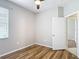 Bedroom with a ceiling fan and wood floors, showcasing an open doorway at 13806 Reindeer Cir, Hudson, FL 34669