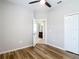 Bedroom view to open bathroom featuring wood flooring and ceiling fan at 13806 Reindeer Cir, Hudson, FL 34669