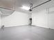 Bright and spacious two car garage featuring clean epoxy flooring and storage racks at 13806 Reindeer Cir, Hudson, FL 34669