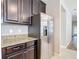 Kitchen featuring stainless steel refrigerator, granite countertops and dark wood cabinets at 13806 Reindeer Cir, Hudson, FL 34669