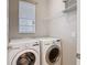 Bright laundry room featuring modern LG washer and dryer, window, and storage shelf at 13806 Reindeer Cir, Hudson, FL 34669