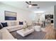 Stylishly staged living room with a plush white sectional and an open concept to the kitchen at 13806 Reindeer Cir, Hudson, FL 34669