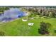 Scenic view of the community park featuring picnic tables, a grilling area, and a dock by the lake at 13806 Reindeer Cir, Hudson, FL 34669
