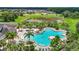 Community swimming pool area with lounge chairs, lush landscaping, and a pond in the background at 13806 Reindeer Cir, Hudson, FL 34669