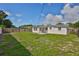 The back of the house has a grassy yard with a small patio area to a back entrance at 1426 Gerard Ln, Holiday, FL 34690