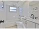 Clean bathroom showcasing a shower-tub combo, white tile, and modern sink with vanity at 1426 Gerard Ln, Holiday, FL 34690