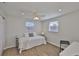 Well-lit bedroom showcases wood floors, ceiling fan, and a comfortable bed with natural light at 1426 Gerard Ln, Holiday, FL 34690