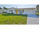 Charming single story home features a bright yellow front door and attached garage at 1426 Gerard Ln, Holiday, FL 34690