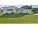 Charming single-story home featuring a well-manicured lawn and inviting yellow front door at 1426 Gerard Ln, Holiday, FL 34690