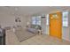 Inviting living room with tile flooring, neutral walls, and bright yellow front door at 1426 Gerard Ln, Holiday, FL 34690