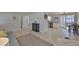 Open living space connects the living room, kitchen, and dining area with neutral tile flooring at 1426 Gerard Ln, Holiday, FL 34690