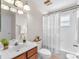 Bright bathroom with a white shower curtain, white vanity, and a mirrored wall cabinet at 15206 Merlinpark Pl, Lithia, FL 33547