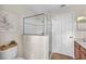 Bright bathroom with glass-enclosed shower and wooden vanity, and a neutral color scheme at 15206 Merlinpark Pl, Lithia, FL 33547