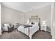 Comfortable bedroom with a metal frame bed, soft gray armchair, and warm, neutral decor at 15206 Merlinpark Pl, Lithia, FL 33547